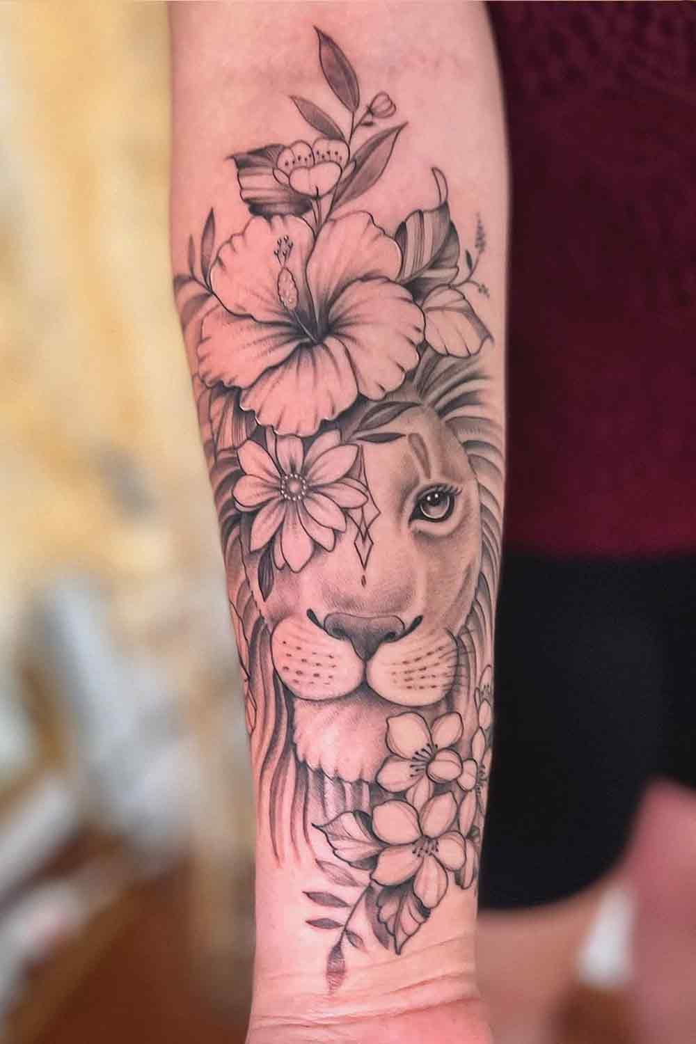 tatuagem-feminina-de-leao-com-flores-no-antebraco 