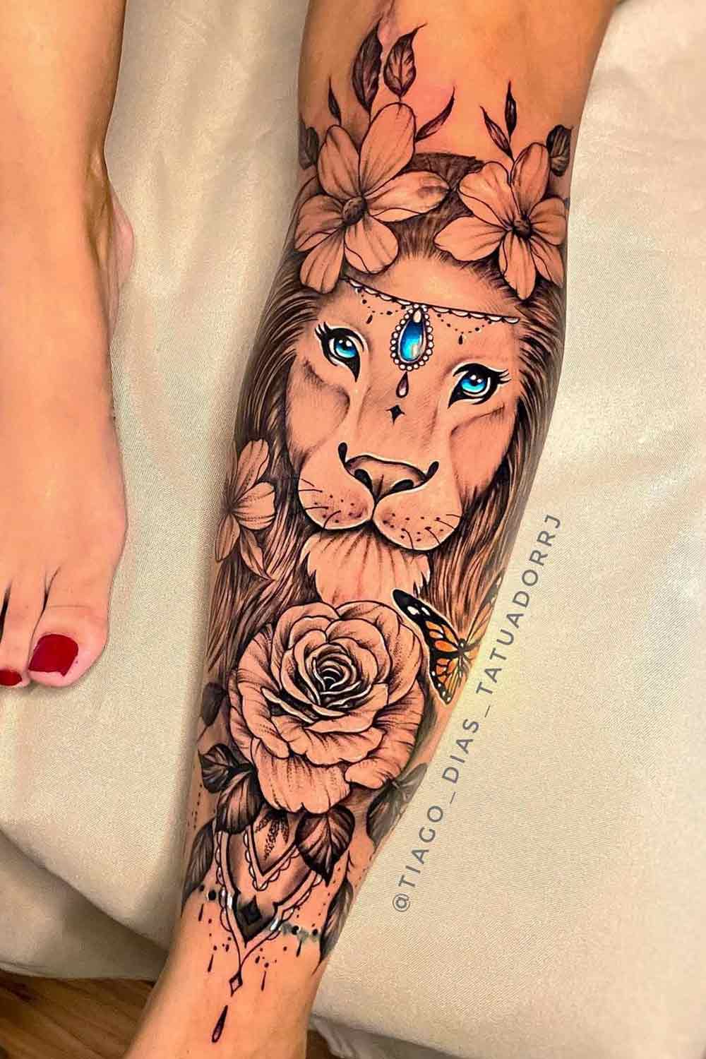 tatuagem-feminina-de-leao-com-rosa-e-flores-na-perna 