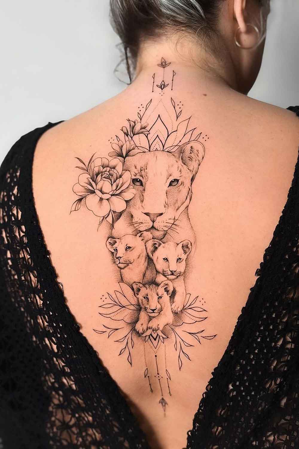 tatuagem-feminina-nas-costas-de-leoa-com-filhotes 