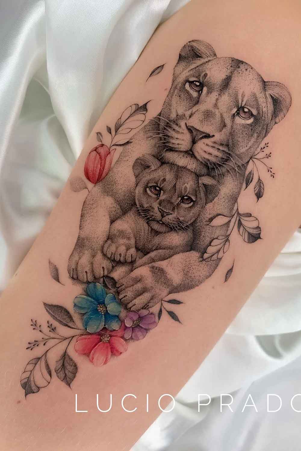 tatuagem-realista-de-mae-leoa-com-filhote-e-flores 