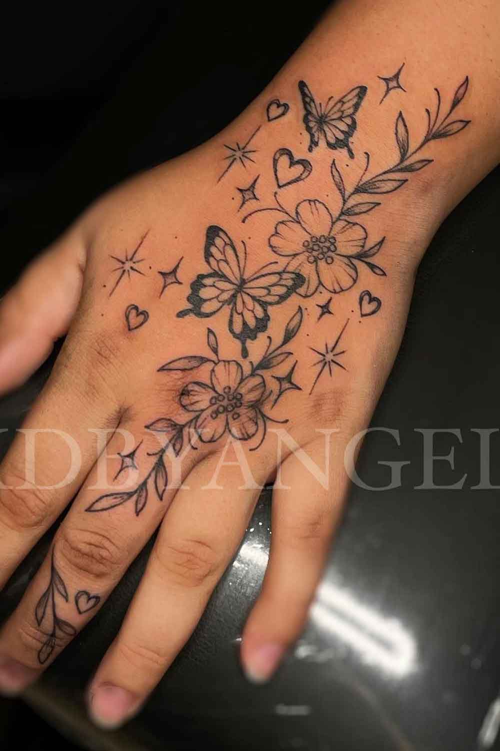 tatuagem-feminina-na-mao-de-borboletas-e-flores 