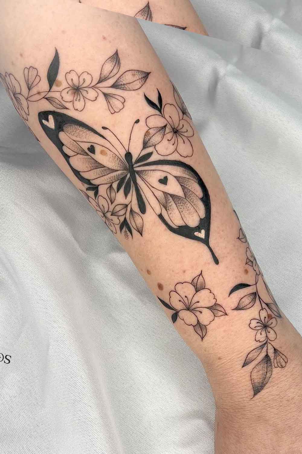 tatuagem-de-borboleta-com-flores-no-braco 